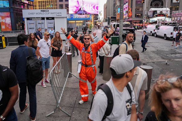 A pedestrian wears a spacesuit during SpaceX's initial public offering (IPO) at the Nasdaq MarketSite in New York.