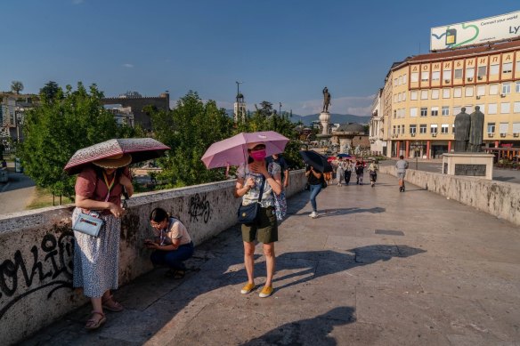 Tourists shade themselves with umbrellas in Macedonia in August.