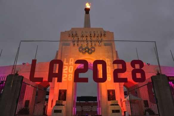 An LA2028 sign is seen in front of a blazing Olympic cauldron at the Los Angeles Memorial Coliseum.