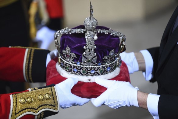 The Imperial State Crown is handed over for the State Opening of Parliament by Queen Elizabeth II, in 2019. 