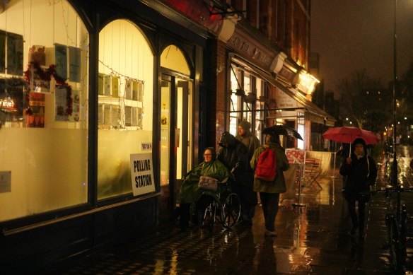 Locals brave the rainy weather to vote at Marchmont Community Center in London.