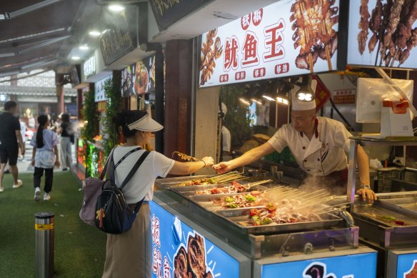 A customer purchase skewers at a food stall in Shanghai.
