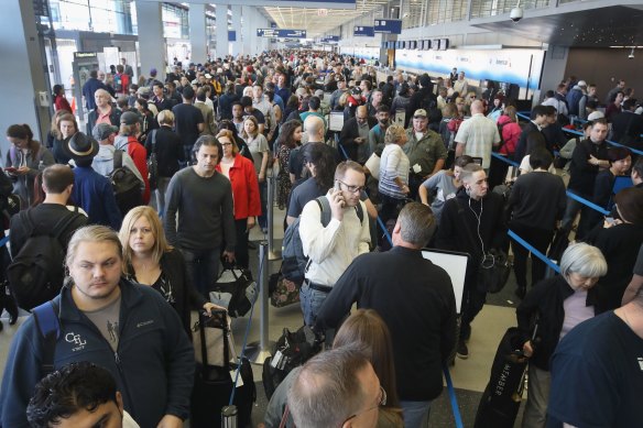 Passengers at Chicago O’Hare International wait to be screened.