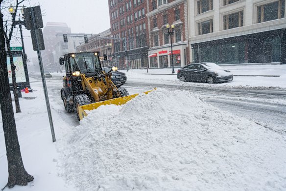 A bulldozer piles up snow in Boston, Massachusetts.