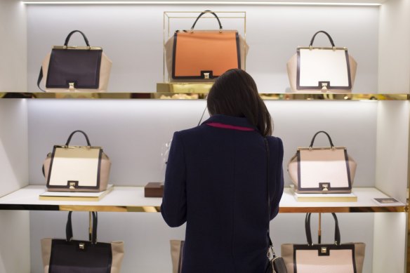 A shopper browses luxury leather handbags in Hong Kong.