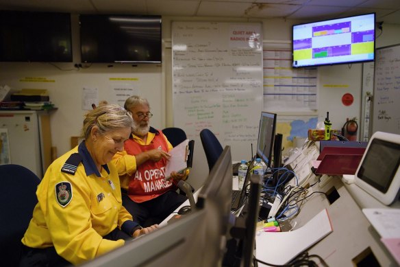 NSW RFS air ops manager Peter Windle (right) and aviation radio operator Danielle Brice (left) working in the operations room at the Eurobodalla operations fire control centre in Moruya.