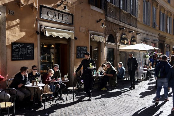 Customers sit outside a cafe in downtown Rome, Italy.