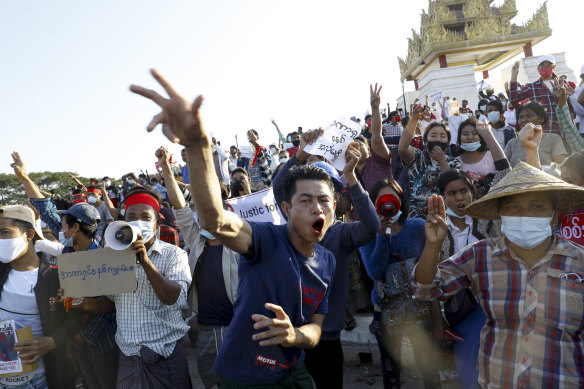 Demonstrators flash a three-fingered symbol of resistance against the military coup and shout slogans calling for the release of detained Myanmar State Counselor Aung San Suu Kyi during a protest in Mandalay, Myanmar in February 2021.