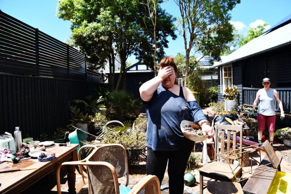 Kym Strow tries to salvage what she can from her Lismore home after the February flood last year.