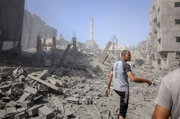 Palestinians at the site of an Israeli strike on buildings in Nuseirat refugee camp.