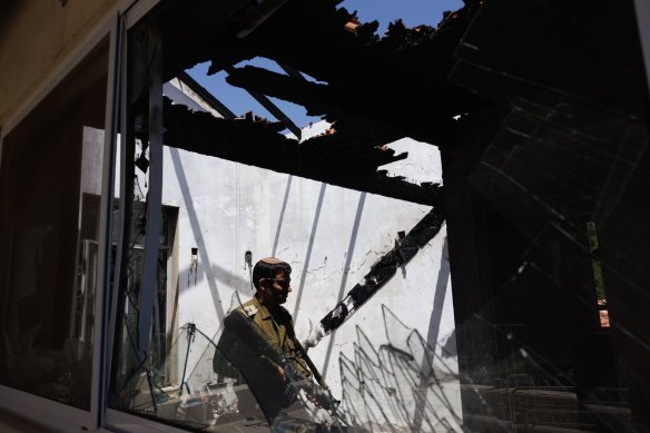 An Israeli soldier in a house damaged by an Hezbollah anti-tank missile near the Lebanon border in Kibbutz Hanita, northern Israel.