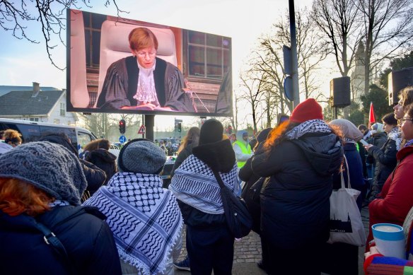 Pro-Palestinian demonstrators watch proceedings at the ICJ on a large screen in The Hague, Netherlands.