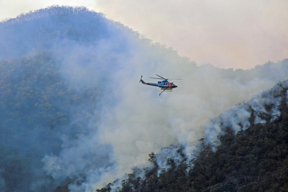 A helicopter waterbombs the fire on August 16.
