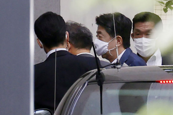 Japanese Prime Minister Shinzo Abe, centre right, arrives at Keio University Hospital in Tokyo on Monday.