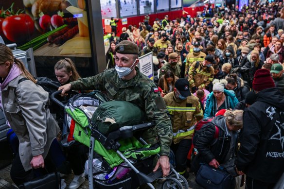 People who fled the war in Ukraine walk towards a humanitarian train in Krakow, Poland to relocate refugees to Berlin.