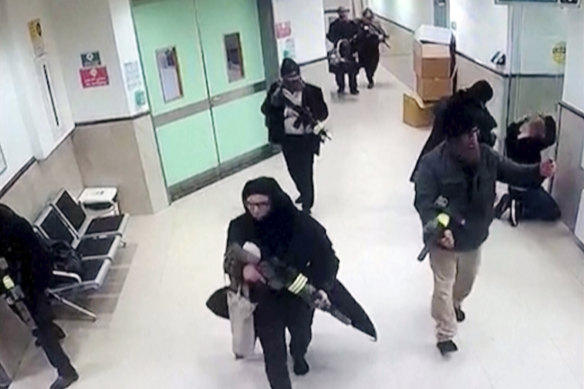 Image taken from surveillance video  shows Israeli forces disguised as civilian women and medical workers hold weapons in a hallway at the Ibn Sina Hospital in the West Bank town of Jenin.