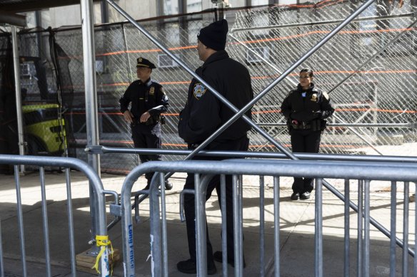 Police officers behind security fences outside the office of Manhattan District Attorney Alvin Bragg.