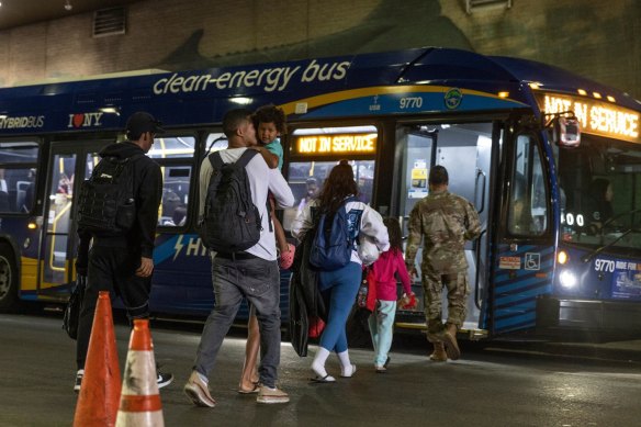 Migrants board a city bus to a shelter intake centre after travelling on a bus from Del Rio, Texas, at the Port Authority Bus Terminal in New York.