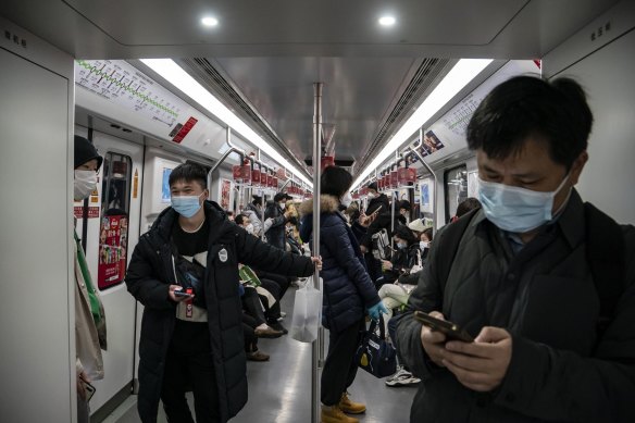 Commuters ride a subway train in Shanghai. China is experiencing an increase in COVID-19-related deaths, but they are not being reported in official government figures.