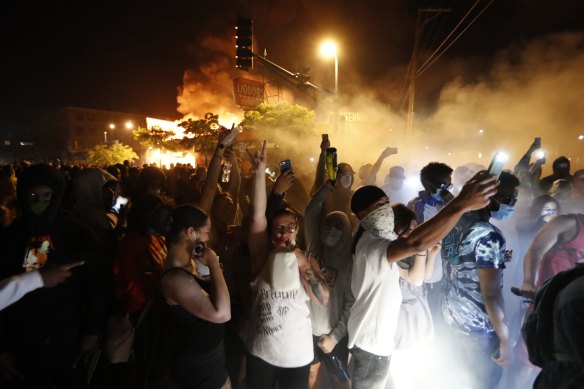 Protesters gather in front of the burning 3rd Precinct building of the Minneapolis Police Department.