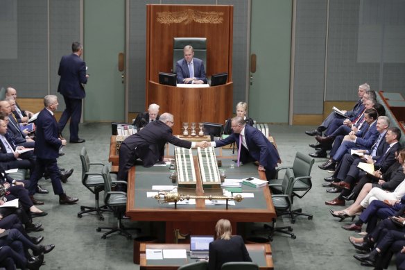 Democracy at work: Prime Minister Scott Morrison reaches across the table to shake hands with Opposition Leader Anthony Albanese.