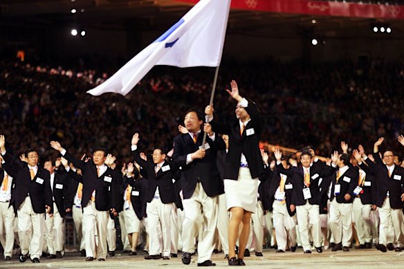 Pak Jung Chul (left) North Korea’s judo coach, and Chung Eun-Sun (right), a South Korean basketball player, are followed by Korean athletes as they carry a flag representing a united Korea during the opening ceremony of the Sydney Olympics.