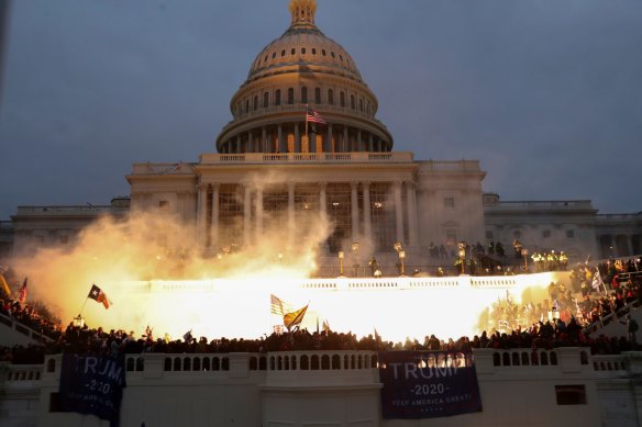 An explosion caused by a police munition is seen while supporters of US President Donald Trump storm the Capitol building. 