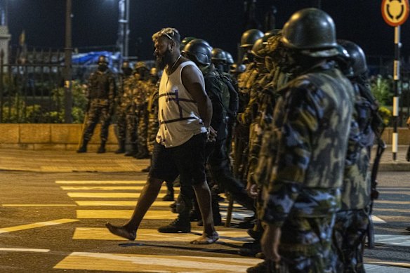 The police and military members detain a demonstrator outside the president’s office in Colombo on Friday.