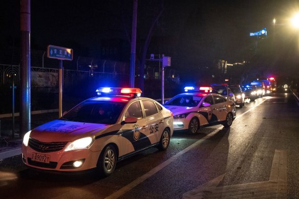 Police cars line up near the site of a planned protest in Beijing on Tuesday night.