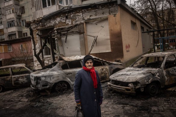 An elderly woman looks at damage caused by overnight Russian shelling of a residential building in Kherson, Ukraine, on December 1.