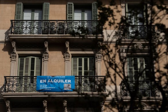 A banner reading “For Rent” hangs from the balcony of a residential apartment in Barcelona.
