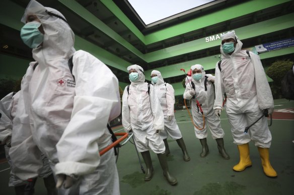 Members of Indonesian Red Cross prepare to disinfect a school in the wake of coronavirus outbreak in Jakarta.