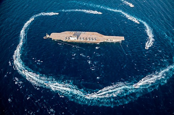 Iranian Revolutionary Guard’s speed boats circle around a replica aircraft carrier during a military exercise in the strategic Strait of Hormuz in 2019.