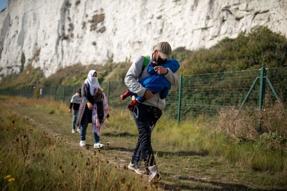 A migrant family walks along the coast  in Deal, England, on September 15. More than 6100 migrants have made the Channel crossing by boat this year according to an analysis by the Press Association. 
