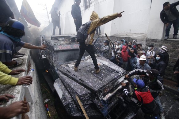 Anti-government demonstrators commandeer an armoured vehicle during a nationwide strike and protest against President Lenin Moreno in Quito, Ecuador.