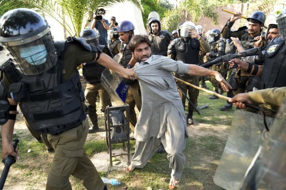 Police detain a supporter of Imran Khan in Lahore.