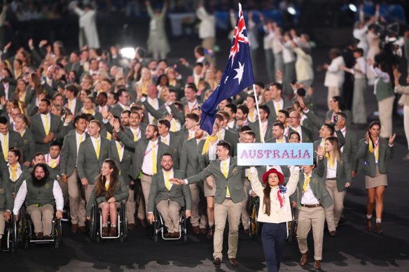 Eddie Ockenden and Rachael Grinham, flag bearers of Team Australis, lead their team out during the opening ceremony.