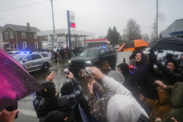 East Palestine residents photograph Donald Trump’s motorcade as he arrives in the town.