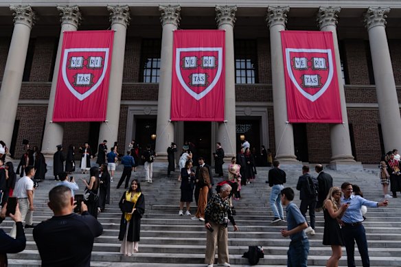 Students take photos on the steps of the Harry Elkins Widener Memorial Library at Harvard University.