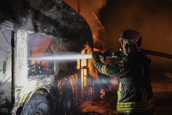 A firefighter tries to put out fire caused by fragments of a rocket after it was shot down by air defence system during the night Russian rocket attack in Kyiv, Ukraine, 