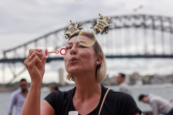 Amelie Faes from Paris blows bubbles into the waiting crowds assembled for the 2023 New Years Eve fireworks. Photo by Cole Bennetts NYE Dec 31, 2022. SMH