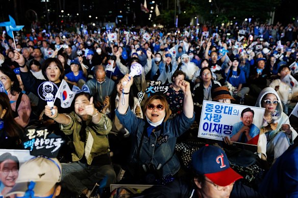 Supporters of Lee Jae-myung celebrate during the vote count near the National Assembly in Seoul.