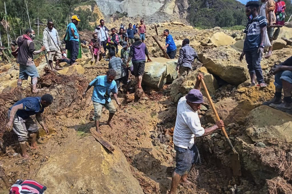 Villagers search through a landslide in Pogera village, in the Highlands of Papua New Guinea.