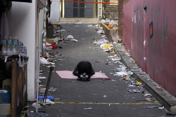 A man bows in the middle of the site of a deadly Halloween crowd crush in Seoul.
