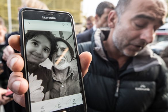 Yama Nabi holds a photo of his father, Haji Daoud, 71, who was killed in the Masjid Al Noor Mosque in Christchurch.