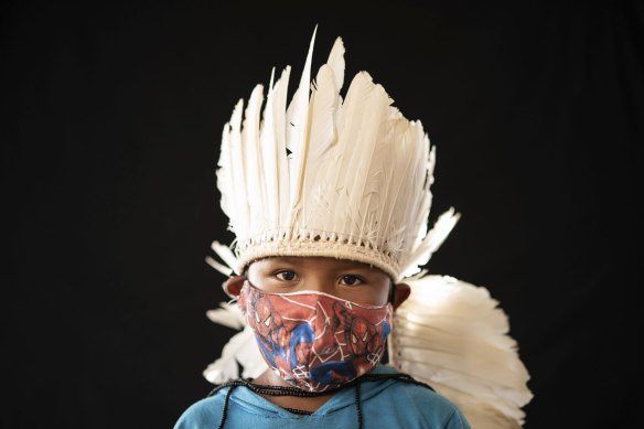 Six-year-old Ezinaldo dos Santosposes wears the traditional dress of his tribe and a Spiderman face mask in the Gaviao community near Manaus, Brazil, on Friday.