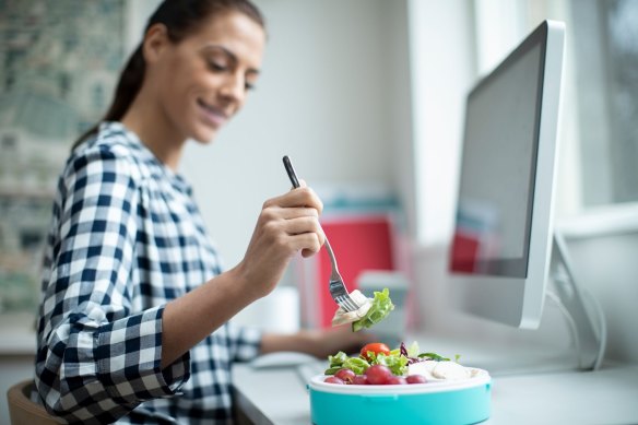 This stock image should be called: Smug office worker enjoys her homemade salad while her idiotic colleagues spend a fortune on sushi.