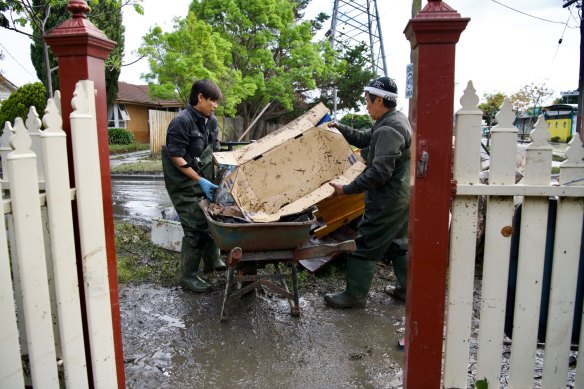 Lam Luong’s husband, Hoang Nguyen, and father-in-law clean up their home on Oakland Street in Maribyrnong. 