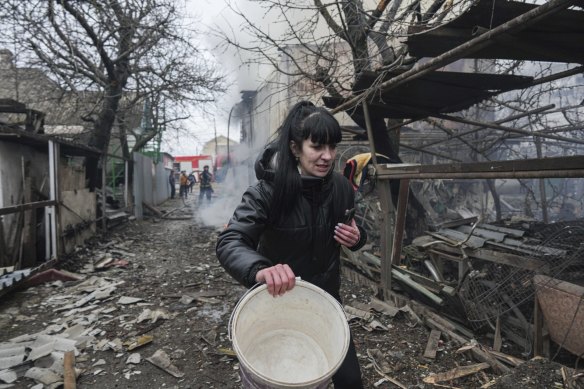 A woman walks past the debris in the aftermath of Russian shelling, in Mariupol on Thursday.