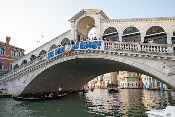 Activists from “No Space For Bezos” hang a protest banner on the Rialto bridge in Venice, Italy, on June 13.